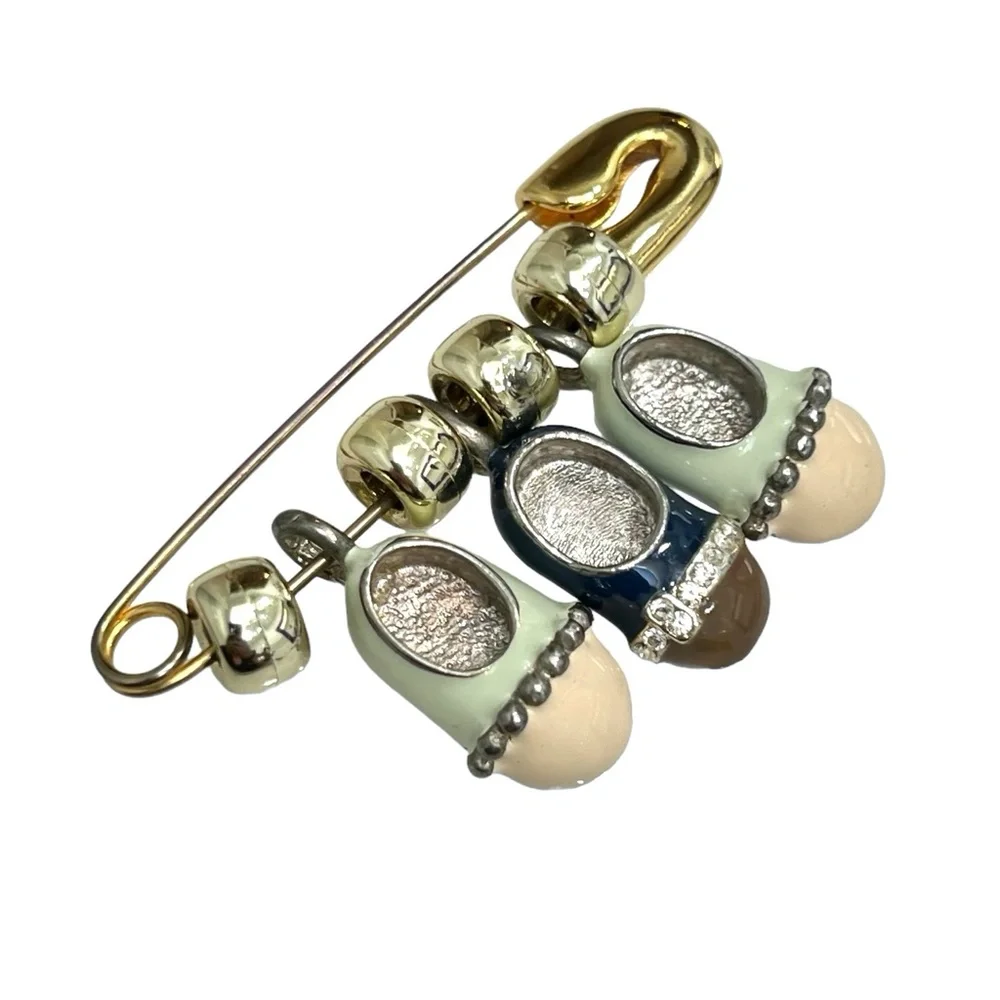 VINTAGE GOLD TONE & ENAMEL SAFETY PIN BROOCH WITH 3 BABY SHOE CHARMS